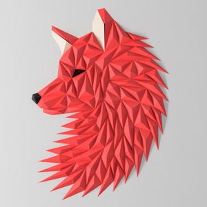 Op de afbeelding: Een rood origami wolfhoofd met een geometrisch ontwerp. De vacht van de wolf is gemaakt van veel kleine driehoeken.
