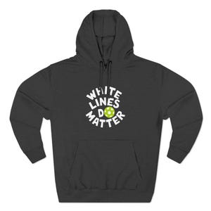 Könnte beinhalten: Dunkelgrauer Kapuzenpullover mit Fronttasche und Kapuze. Der Kapuzenpullover trägt den weißen Text "WHITE LINES DO MATTER" mit einer grün-gelben Ballgrafik in der Mitte. Der Kapuzenpullover ist aus einem weichen Material.