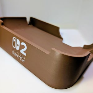 Kątowa stacja dokująca do konsoli Nintendo Switch 2, zapewniająca maksymalny przepływ powietrza: opcjonalne gniazda Quick Swap na wkłady z grami (mieści 4 sztuki) Brązowy