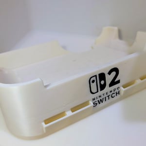 Kątowa stacja dokująca do konsoli Nintendo Switch 2, zapewniająca maksymalny przepływ powietrza: opcjonalne gniazda Quick Swap na wkłady z grami (mieści 4 sztuki) Biały