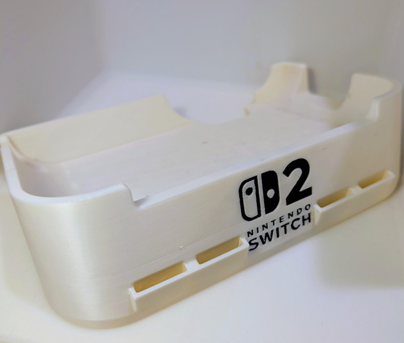 Kątowa stacja dokująca do konsoli Nintendo Switch 2, zapewniająca maksymalny przepływ powietrza: opcjonalne gniazda Quick Swap na wkłady z grami (mieści 4 sztuki) Biały