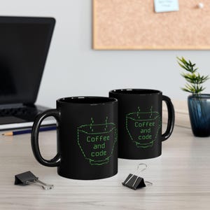 May include: Two black coffee mugs with a green code design that reads "Coffee and code".