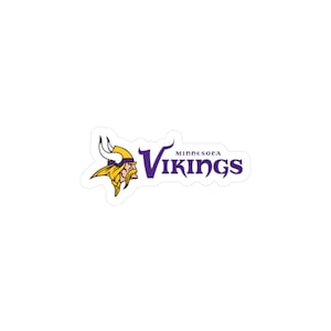 Può includere: Un adesivo bianco con il logo dei Minnesota Vikings. Il logo presenta una testa di vichingo in giallo e viola, con il nome della squadra in testo viola.