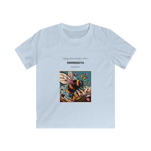 Può includere: Maglietta blu chiaro con una grafica di un'ape su un fiore. Il testo "Ring Piccolo Bandalora MINNESOTA Bombus affinis" è stampato sulla maglietta.