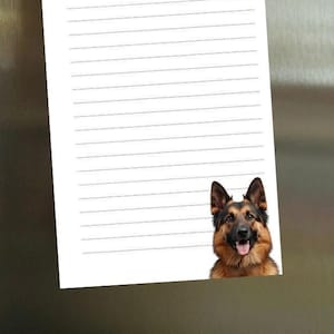 May include: A white Things To Do list notepad with horizontal lines and the text "THINGS TO DO" in black. A German Shepherd dog image is at the bottom right. The notepad is attached to a stainless steel refrigerator.