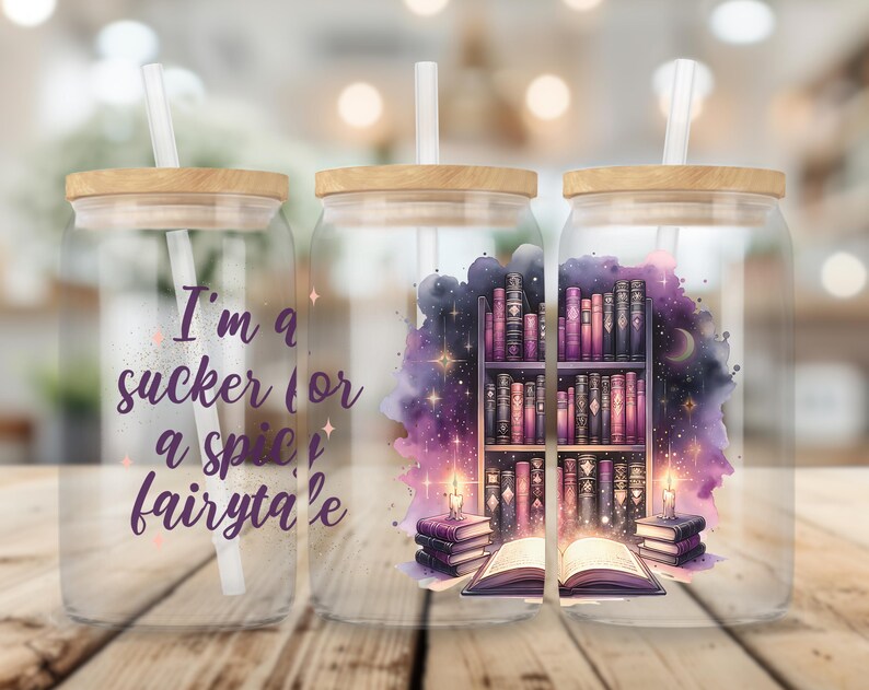 May include: Three glass jars with bamboo lids and straws. The jars have a watercolor design of a bookshelf with books and a glowing book in front of it. The text on the jar reads "I'm a sucker for a spice fairy tale".