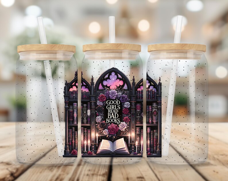 May include: Three clear glass tumblers with lids and straws. Each tumbler features a black and white illustration of a bookshelf with books and a gothic archway. The center tumbler has the text "Good Girls Read Bad Books" in the archway.