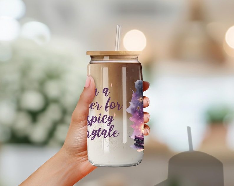 May include: A clear glass tumbler with a gold lid and a straw. The tumbler has a purple and pink watercolor design with stars and the text "Once a reader for a spicy fairytale".