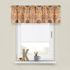 May include: A valance with a floral pattern in shades of orange, yellow, blue, and green. The valance is made of a textured fabric and has a ruffled edge.