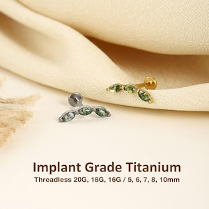 May include: Two threadless labret studs made of implant grade titanium, one in silver tone and one in gold tone. Each features a curved bar set with three marquise-cut green moss agate stones. Text reads: Implant Grade Titanium Threadless 20G, 18G, 16G / 5, 6, 7, 8, 10mm.