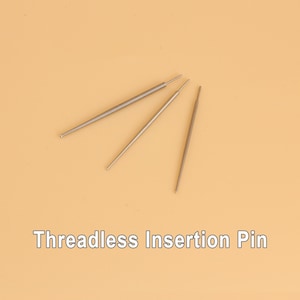 May include: Three silver threadless insertion pins are displayed against a light orange background. The pins are thin, straight, and have a slightly thicker end. The text "Threadless Insertion Pin" is printed in white at the bottom of the image.