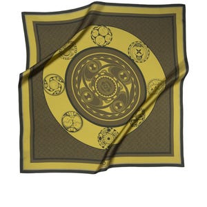 May include: A yellow silk scarf with a brown geometric design. The design features a large circle with smaller circles around it. The scarf is folded and draped over a white background.
