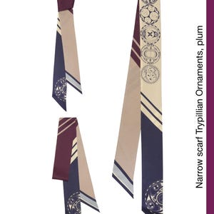 May include: Narrow plum scarf with Trypillian ornaments. The scarf features a geometric pattern in beige, navy, and plum. The design includes circles and lines. The text on the side reads "Narrow scarf Trypillian Ornaments, plum."