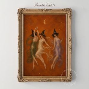 Pode incluir: Uma impressão artística emoldurada intitulada Moonlite Prints Co apresentando três figuras com chapéus pontiagudos dançando contra um fundo laranja profundo com uma lua crescente e estrelas. As figuras usam vestes fluidas e transparentes.