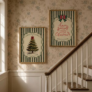 May include: Two rectangular framed wall art prints featuring a dark green and cream vertical striped background. One print displays a decorated Christmas tree with a red bow, while the other features the text Have yourself a merry little Christmas.