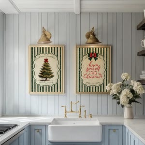 May include: Two rectangular wall art prints featuring a green and white vertical striped background. One print displays a decorated Christmas tree with a red bow, while the other features the text Have yourself a merry little Christmas in red.