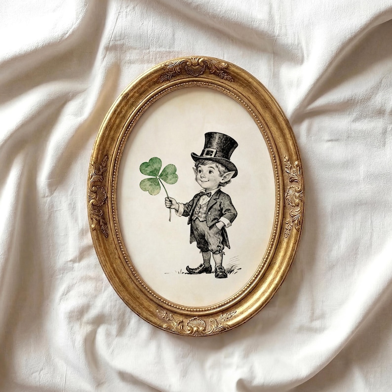 May include: An oval, gold-colored framed print featuring a black and white illustration of a leprechaun holding a three-leaf clover. The leprechaun is wearing a top hat, suit, and shoes. The frame has ornate detailing.