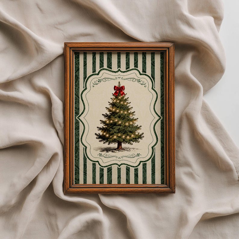 May include: A rectangular wooden frame containing a print of a green Christmas tree with glowing lights and a red bow on top. The print features a cream-colored central scalloped label set against a background of dark green and cream vertical stripes.