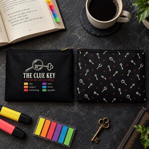 May include: Two black rectangular zippered pouches. One pouch features a graphic of a magnifying glass over a key, the text THE CLUE KEY, trust no one, tab everything, and a color-coded legend. The other pouch has a repeating pattern of keys.