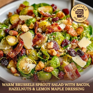 Op de afbeelding: Een warme spruitjessalade met spek, hazelnoten en cranberries. De salade is gegarneerd met geraspte Parmezaanse kaas en een dressing van citroen en ahornsiroop. Printbare PDF-recept inbegrepen.