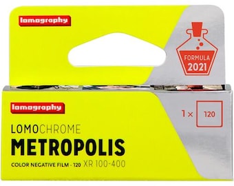 Puede incluir: Una caja amarilla y plateada de película negativa en color Lomography LomoChrome Metropolis. La caja presenta el logotipo de Lomography, el nombre de la película y el texto "COLOR NEGATIVE FILM 120 XR 100-400". La caja también tiene una etiqueta "FORMULA 2021".