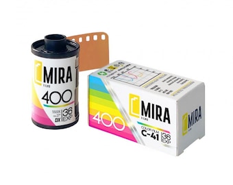 Puede incluir: Un rollo de película a color de 35mm y su caja de cartón rectangular a juego. El cartucho y la caja son blancos con una franja de degradado arcoíris, con el texto MIRA 400, 36 EXP y C-41. La caja muestra un gráfico de sensibilidad técnica.