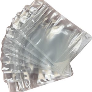 May include: A stack of clear, rectangular plastic pouches arranged in a fan shape. Each pouch features a resealable zipper closure at the top and heat-sealed edges on the sides and bottom, providing a transparent view of the interior space.