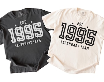 May include: Two t-shirts, one black and one white, with the text "EST. 1995 LEGENDARY TEAM" printed on the front.
