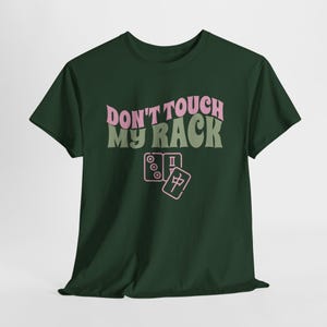 Może przedstawiać: Zielony T-shirt z napisem "Don't Touch My Rack" w kolorze r&oacute;żowym i zielonym. Tekst jest w retro stylu czcionki. Pod tekstem znajdują się dwa r&oacute;żowe kostki domina.