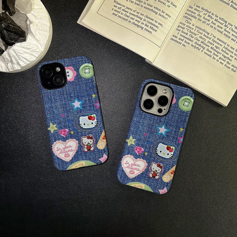 May include: Two blue denim iPhone cases with Hello Kitty and star designs. The cases have a pink heart with the text "In your dreams" and a white Hello Kitty character with a red bow.