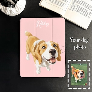 May include: A light pink tablet case featuring a custom illustration of a beagle dog with white and tan fur. The case displays the name "Nikah" in white script with a heart icon. A dashed line connects the illustration to a small dog photo.