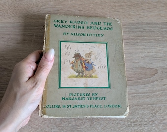 Könnte beinhalten: Ein Vintage-Buch mit dem Titel "Grey Rabbit and the Wandering Hedgehog" von Alison Uttley. Das Cover zeigt eine Illustration eines Kaninchens und eines Igels. Herausgegeben von Collins, 14 St. James's Place, London.