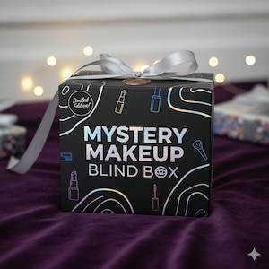 May include: A black square gift box tied with a silver ribbon and a gold seal. The box displays the text "Mystery Makeup Blind Box" in a holographic font, with cosmetic illustrations. The words "Limited Edition!" are also visible.