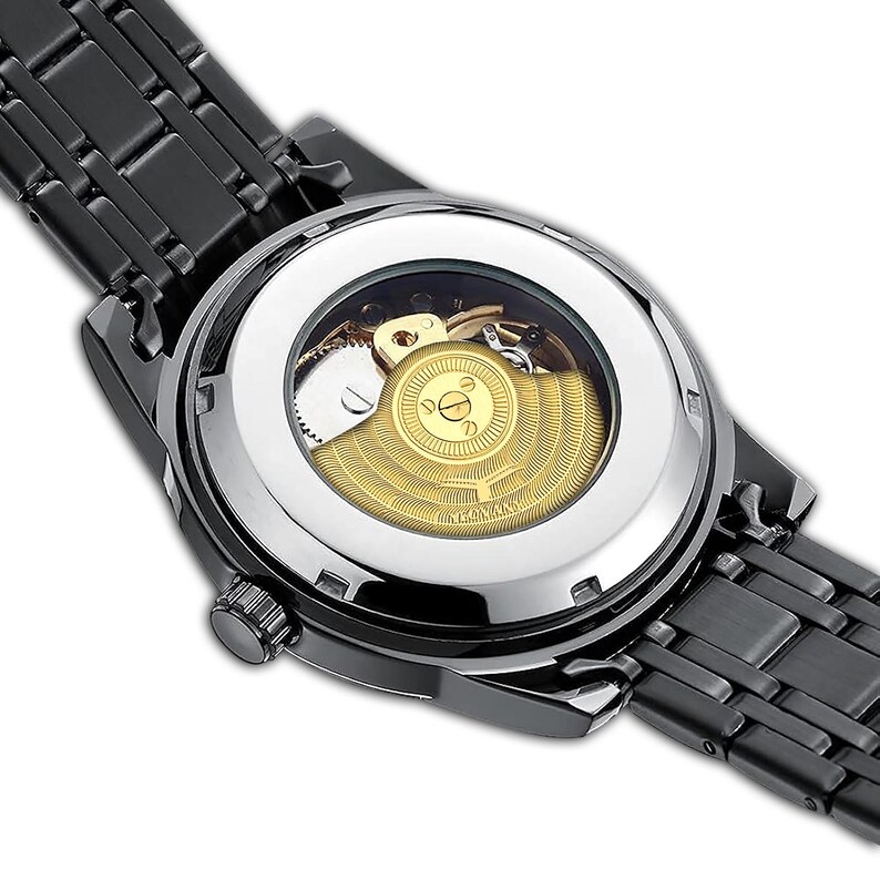 May include: A black stainless steel watch with a silver face and a visible automatic movement. The watch has a black leather band.