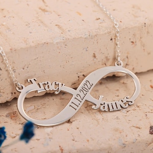 May include: Silver infinity necklace with the names "Tracy" and "James" and the date "11.12.2022" engraved on it.