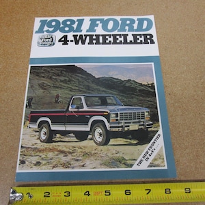 May include: An advertisement for the 1981 Ford 4-Wheeler pickup truck. The image shows a black and silver truck on a dirt road with a mountain backdrop. The text at the top reads "1981 FORD 4-WHEELER".