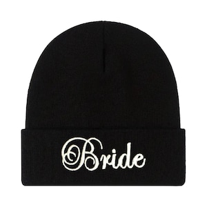 May include: Black knit beanie with a white embroidered word "Bride" on the front.