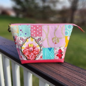 May include: Pink and white patchwork zippered pouch with a pink poodle, a fire hydrant, and a heart with the text "Best Friend" on it.