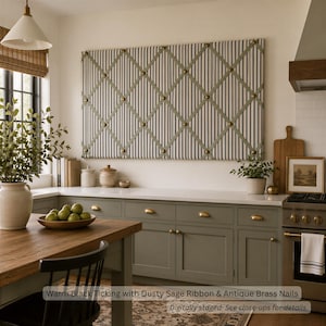 May include: A rectangular fabric memo board featuring a black and white ticking stripe pattern, accented with a crisscross dusty sage ribbon overlay and secured at each intersection with round antique brass nail head decorative tacks.