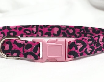 May include: Pink cat collar with a black leopard print pattern and a pink plastic buckle.