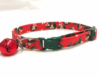 May include: Red and green floral patterned cat collar with a silver bell.