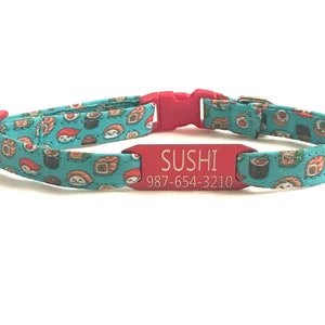 May include: A red cat collar with a turquoise fabric pattern of sushi rolls. The collar has a red engraved tag that reads "SUSHI 987-654-3210".