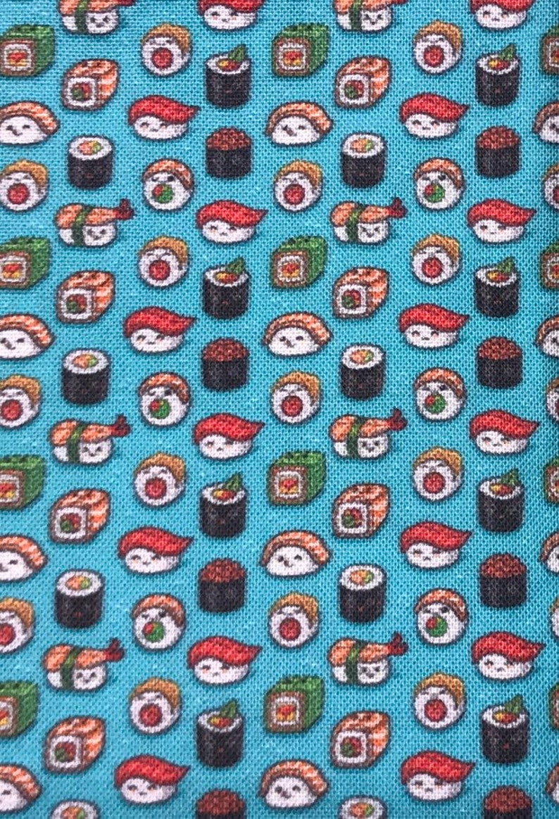 May include: A blue fabric with a repeating pattern of various sushi rolls. The sushi rolls are in different colors and shapes, including salmon, avocado, and cucumber.