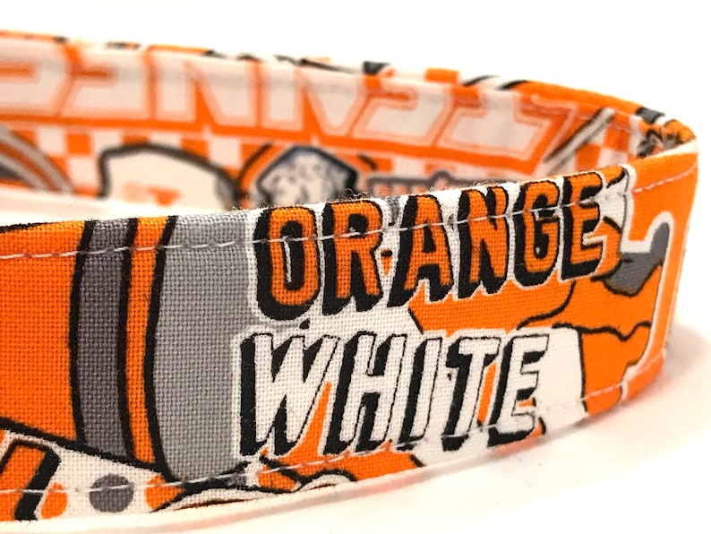 Puede incluir: Tela naranja y blanca con las palabras "ORANGE WHITE" impresas en negro.