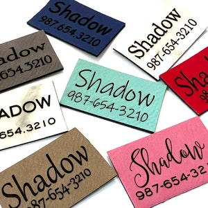 May include: A collection of nine different color fabric tags with the word "Shadow" and the phone number 987-654-3210 printed on each tag.
