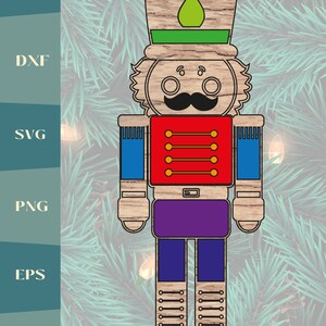 May include: A wooden nutcracker ornament with a green hat, red jacket, blue sleeves, purple pants, and brown boots. The nutcracker has a mustache and a friendly face.