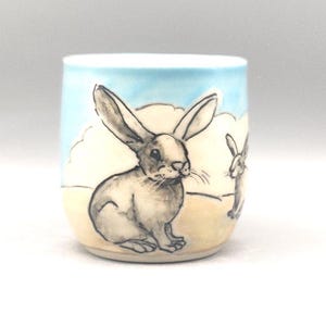 Small handmade, handpainted ceramic mug; two big-eared hares in a landscape