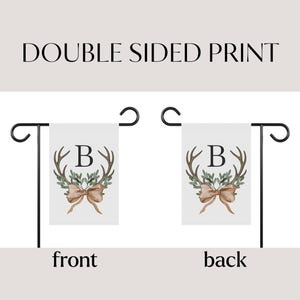 May include: Double-sided garden flag with a white background. The flag features a watercolor design of antlers, greenery, and a bow, with the letter "B" in the center. The text "DOUBLE SIDED PRINT" is at the top.