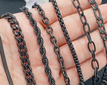 May include: A set of six black chain necklaces with different link styles, including a curb chain, a rope chain, a box chain, a cable chain, and a figaro chain.