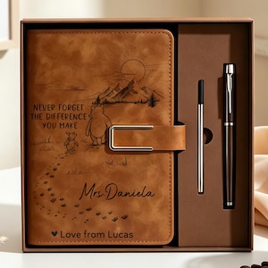 Peut inclure: Un carnet en similicuir beige avec un fermoir métallique, gravé d'un paysage de montagne, de Winnie l'ourson et Porcinet, avec le texte "NEVER FORGET THE DIFFERENCE YOU MAKE", "Mrs. Daniela" et "♥ Love from Lucas". Inclut un stylo assorti.